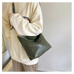 Detailed view of dark green leather tote with bohemian print wide fabric shoulder strap