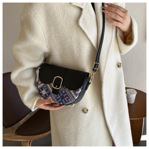 Detail of saddle bag featuring ethnic geometric woven fabric and gold oval buckle