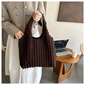 Sac hobo marron à texture bulle et plis popcorn présenté dans un cadre de vie décontracté
