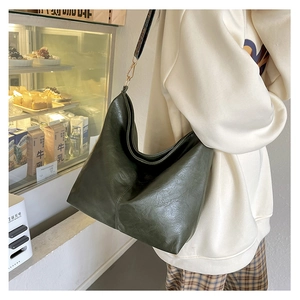 Close-up of deep green hobo bag with litchi texture and adjustable shoulder strap