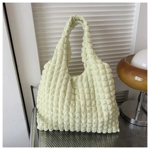 Détail de la texture bulle vert clair sur un sac à bandoulière froncé minimaliste