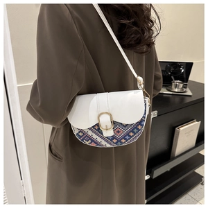 Ethnic style saddle bag with geometric jacquard pattern and gold buckle on a white flap