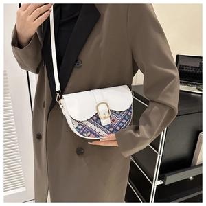 Close-up of bohemian saddle bag with colorful geometric embroidery and gold buckle