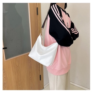Detail of white tote bag with vintage patterned wide shoulder strap and gold hardware