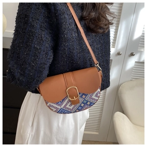 Detail of vintage saddle bag featuring retro geometric woven fabric and leather flap