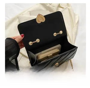Interior view of black quilted crossbody bag showing space for smartphone and small wallet