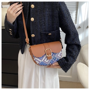 Detail of retro saddle bag featuring colorful geometric woven fabric and brown leather