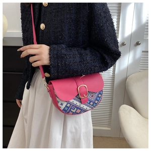 Detail of pink semi-circle saddle bag with bohemian weave and gold metal buckle