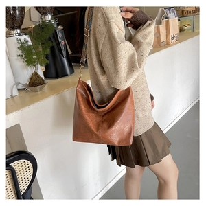 Brown faux leather tote bag with a wide colorful geometric pattern woven strap details