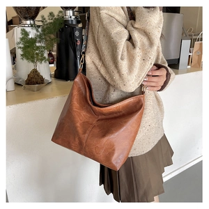 Detail of vintage PU leather tote with a colorful ethnic woven shoulder strap