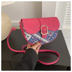 Detail of semicircular saddle bag featuring ethnic embroidery and golden buckle strap