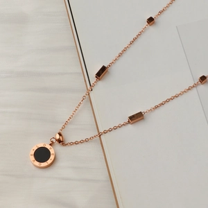 Rose gold stainless steel LOVE necklace with black circular pendant and geometric beads