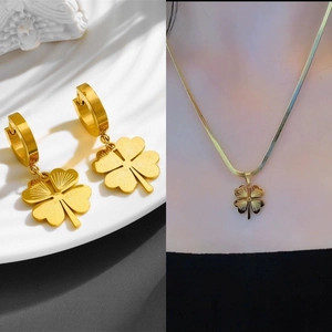 Golden clover jewelry set featuring engraved clover leaf pendant necklace and hoop earrings