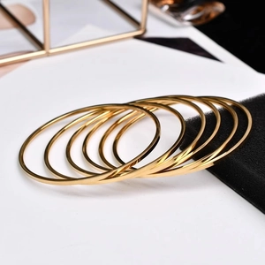 Set of minimalist 2mm gold plated stainless steel bangles with polished mirror finish