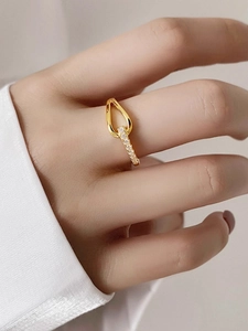 Détail d'une bague en or 18 carats avec pavé de diamants portée par un mannequin chic