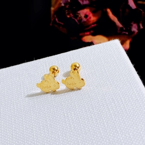Festive gold rabbit stud earrings with luck engraving on white textured card