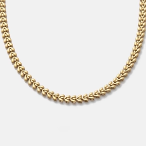 Detailed close-up of a golden wheat chain necklace with intricate leaf-shaped links