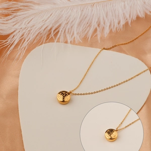 Double-sided gold Fu and Xi character pendant necklace on champagne satin background