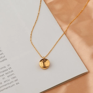 Golden titanium steel necklace with Fu character pendant on elegant silk background