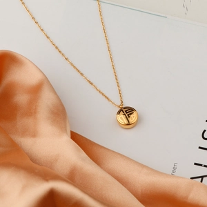 Golden titanium steel necklace with Fu character pendant on elegant silk background