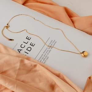 Detail of 18K gold-plated stainless steel necklace with double-sided Fu character pendant