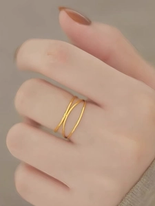 Detailed view of gold triple layered minimalist interlaced ring on a finger