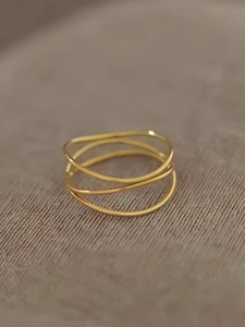 Detailed close-up of triple-layered interwoven gold-tone thin band rings for women