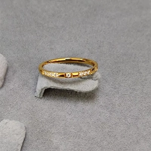 Detailed view of a gold-plated titanium ring featuring a micro-paved row of zircon crystals