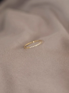 Detalle macro de anillo fino de acero de titanio con circonitas sobre tela suave