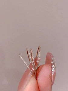 Close-up of three stackable rose gold rings with a shimmering frosted sand texture finish