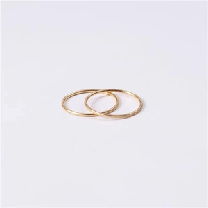 Detailed view of two minimalist golden glitter frosted rings stacked on a grey background