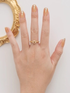 Détail d'une bague en pierre jaune avec halo de diamants et anneau torsadé fini
