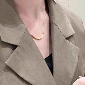 Elegant gold-plated geometric square bead necklace worn by a model in formal attire