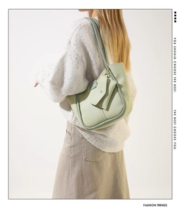 Detail of light green bucket bag with a detachable matching coin purse on a model