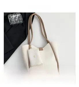 Detail of cream white bucket bag set with brown trim and small detachable pouch