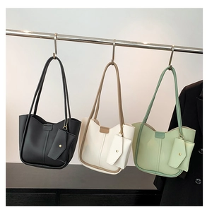 Three-color minimalist tote bag set hanging on metal hooks in black, white, and green
