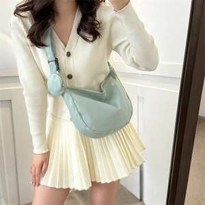 Minimalist mint green nylon crescent crossbody bag with a wide strap and small round pouch