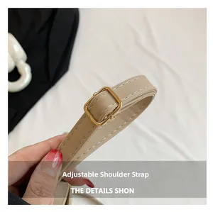 Detail of adjustable beige synthetic leather shoulder strap with golden metal buckle
