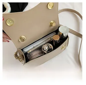 Internal view of beige crossbody bag showing space for phone and makeup items
