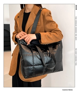 Detail of black quilted tote bag with puffer padding and shiny nylon fabric finish