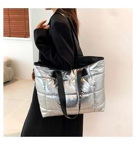 Close-up of quilted silver tote bag with metallic texture and black nylon straps