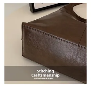 Close-up of precise stitching craftsmanship on dark brown retro leather tote bag