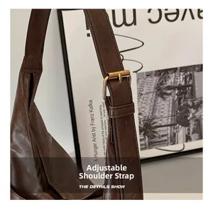 Detail of adjustable strap with gold buckle on brown vintage faux leather tote bag