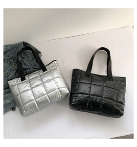 Detailed macro view of quilted puffer tote bags in metallic silver and black colors