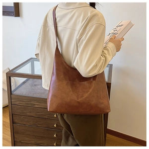 Close-up of the vintage brown faux leather tote bag with wide shoulder strap