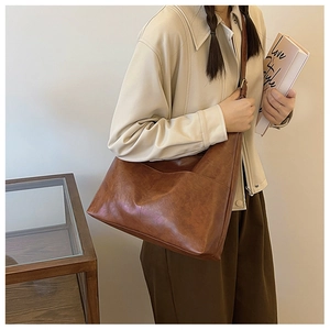 Detail of vintage brown leather tote bag showing soft texture and adjustable strap