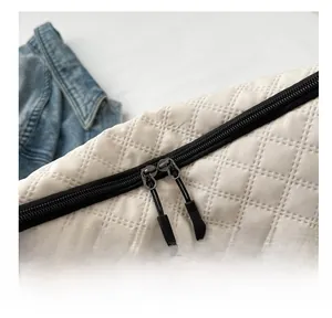 Detail of smooth double zipper and quilted texture on white casual shoulder bag