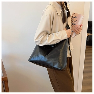 Minimalist black shiny PU leather tote bag with subtle wrinkled texture and adjustable strap