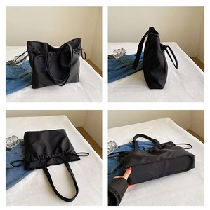 Détails d'un grand sac cabas noir imperméable montrant le cordon de serrage latéral