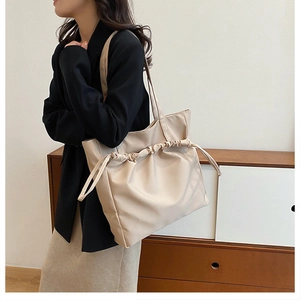 Détail du sac cabas beige avec cordon de serrage plissé et doubles bretelles longues